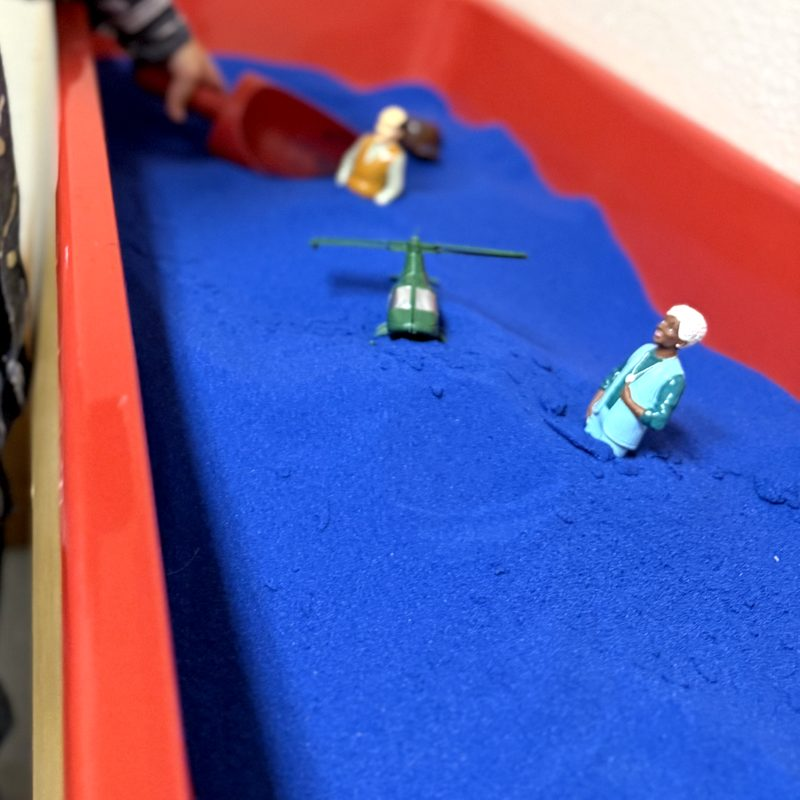 Small figures in a blue sand tray